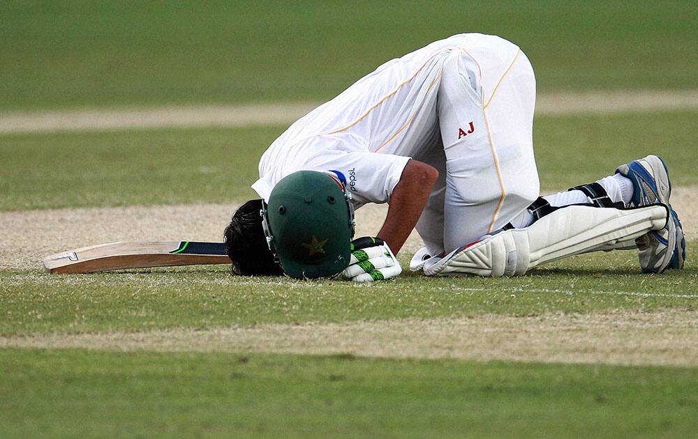 Pakistan batsman Younis Khan celebrates his 9000th runs in test cricket during the Pakistan and England Test match at the Dubai International Stadium in Dubai.