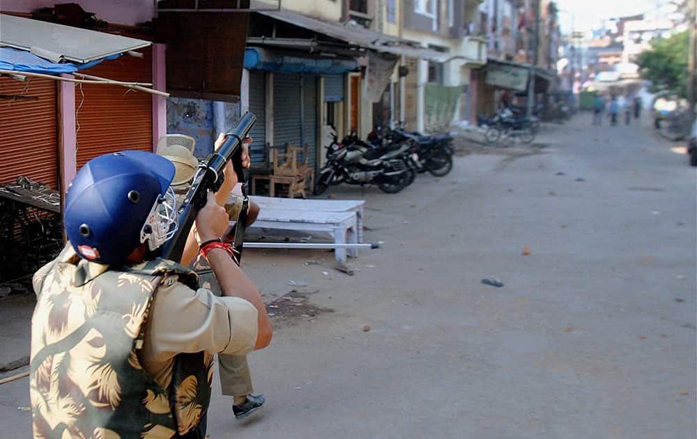 A police man fires teargas shell to control people after clashes during a Muharram procession in Kanpur.