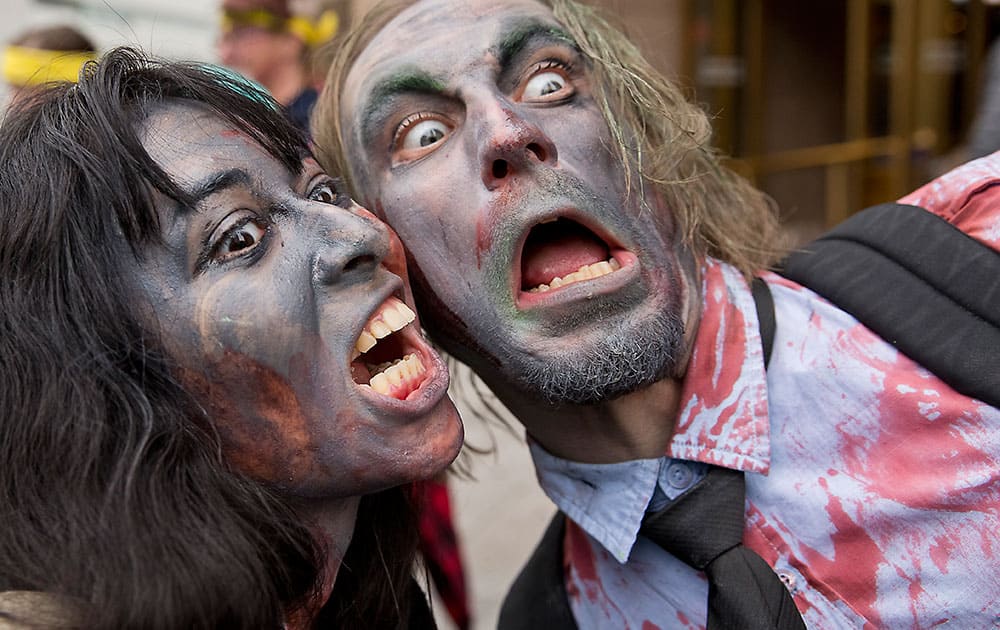 Dressed as zombies Jessica Hernandez, left, and Derek Rooney prepare for the start of the city's 10th annual