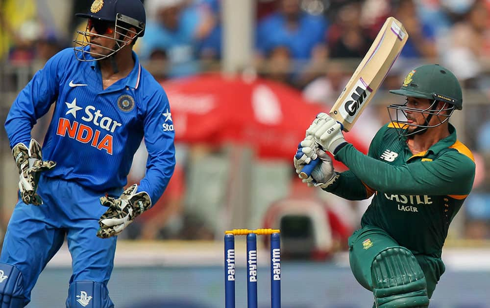 India's captain Mahindra Singh Doni, watches as South Africa’s Quinton de Kock plays a shot during the final one-day international cricket match of a five-game series in Mumbai, India.