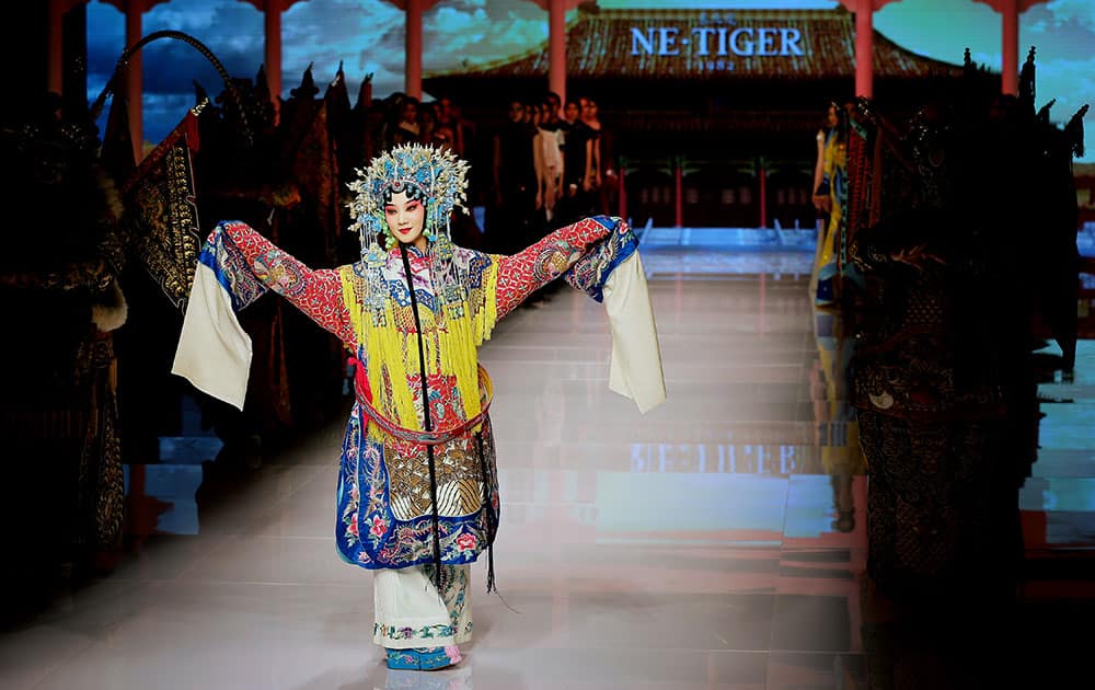 An artist dressed in an Chinese opera costume performs during the NE TIGER Haute Couture 2015 collection with the 