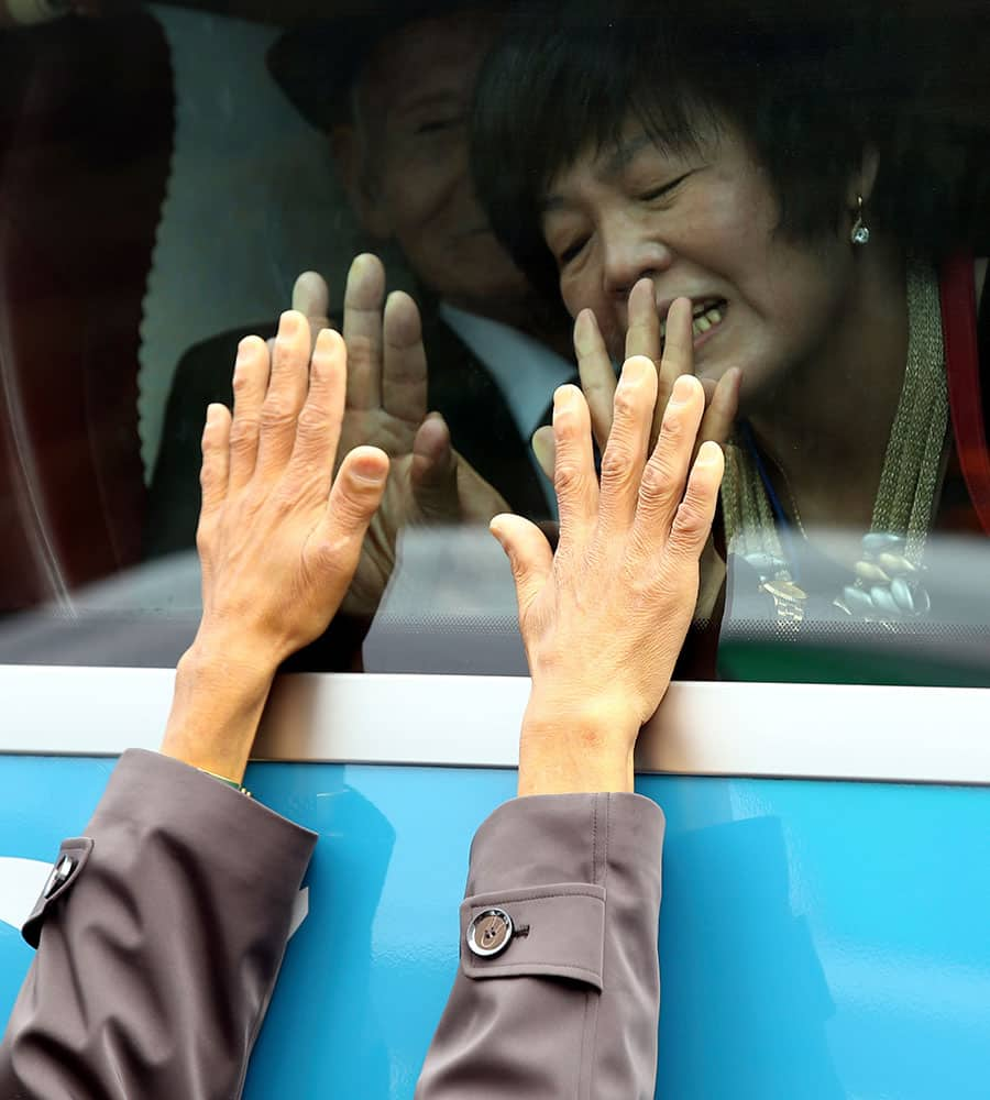 An unidentified South Korean woman on a bus touches the bus window in her attempt to feel the hands of her North Korean relative as they bid farewell after the Separated Family Reunion Meeting at Diamond Mountain resort in North Korea.