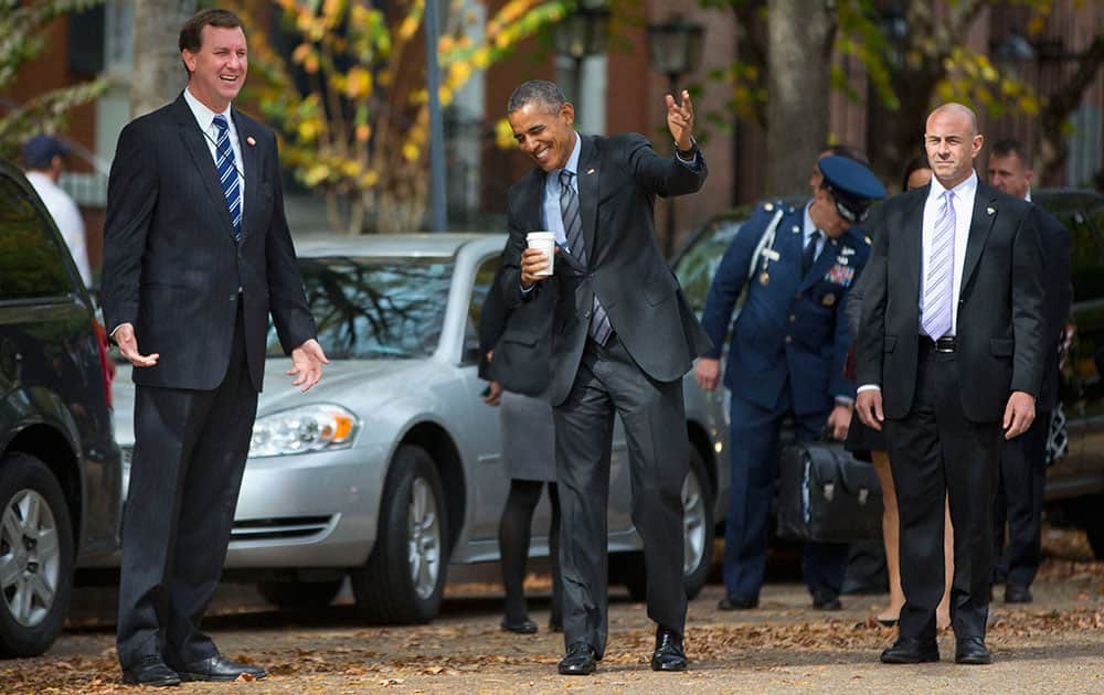 President Barack Obama gestures to members of the media to keep moving as he walks back to the White House in Washington.