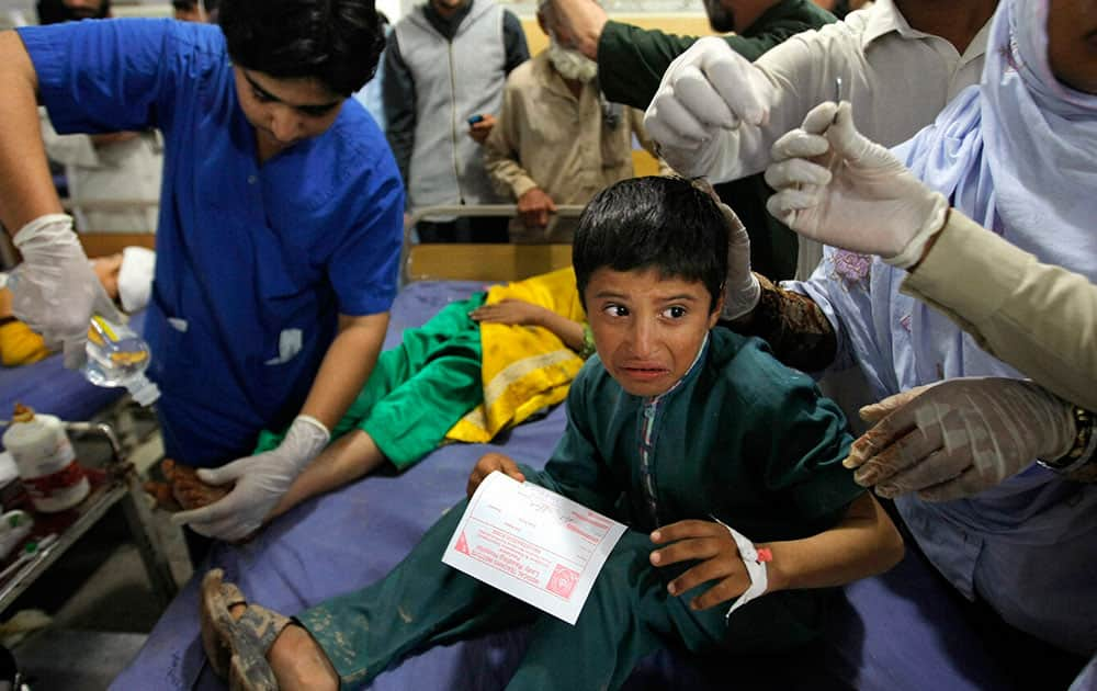 Pakistani doctors treat patients at a hospital after an earthquake hit, in Peshawar.