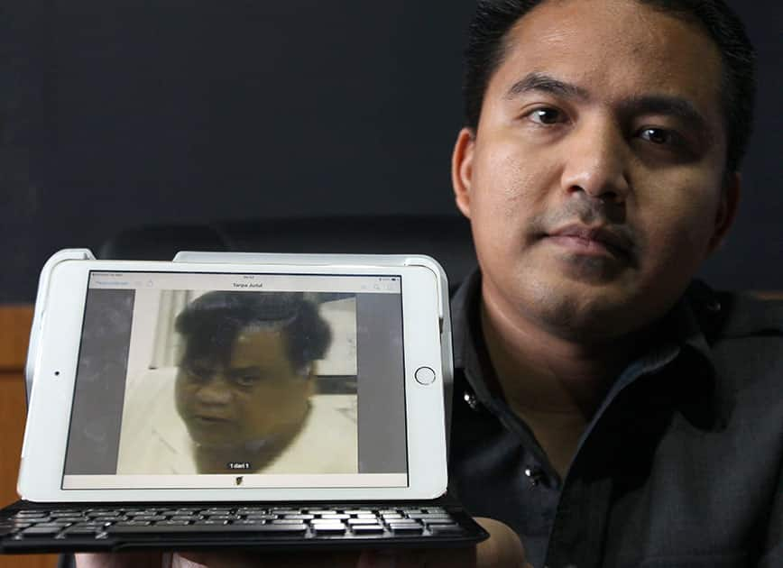 Denpasar Police chief detective Reinhard Habonaran Nainggolan holds a photo of Mohan Kumar alias Rajendra Sadashiv Nikalje is detained in Bali, Indonesia.