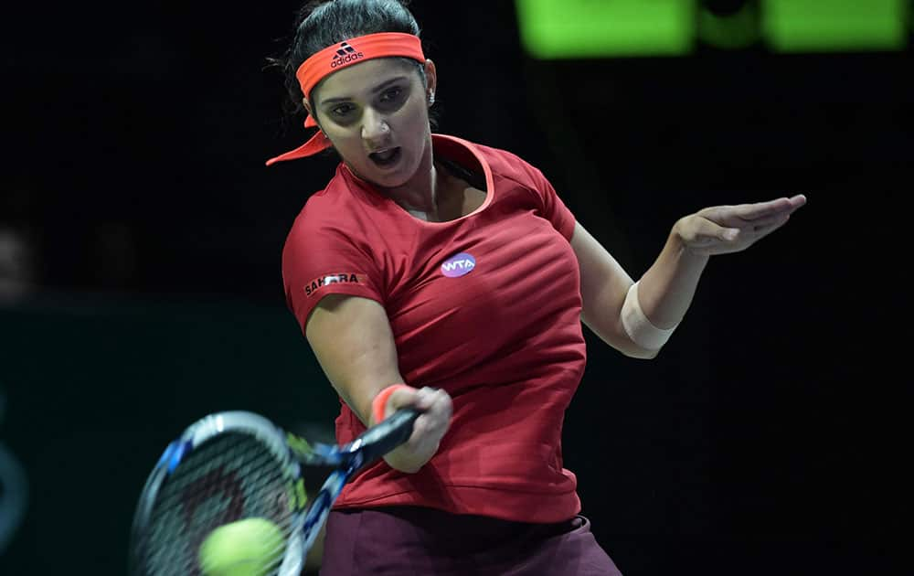 Sania Mirza of India makes a forehand return as she plays with her partner Martina Hingis of Switzerland against Andrea Hlavackova and Lucie Hradecka, both of the Cech Republic during their doubles match at the WTA tennis finals in Singapore.