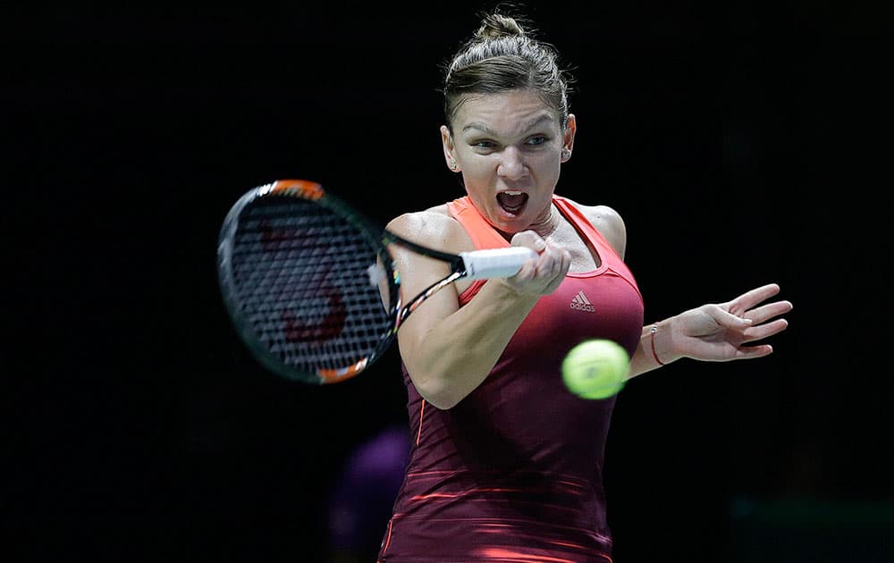 Simona Halep of Romania makes a forehand return against Agnieszka Radwanska of Poland during their singles match at the WTA tennis finals in Singapore.