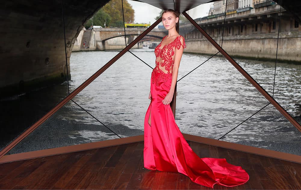 A model displays a creation as part of the Jessica Minh Anh Autumn Fashion Show on a floating catwalk set up in a boat cruising on the Seine river, in Paris.