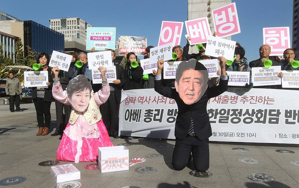 Protesters wearing masks of Japanese Prime Minister Shinzo Abe, right, and South Korean President Park Geun-hye stage a rally against Abe's planned visit in Seoul, South Korea. Abe and Chinese Premier Li Keqiang will visit Seoul for their trilateral summit with Park. The letters on the cards read 'Oppose Abe's visit and a summit meeting between South Korea and Japan.'