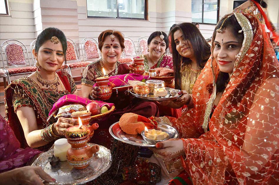 Women perform rituals as they celebrate Karva Chauth, in Noida.