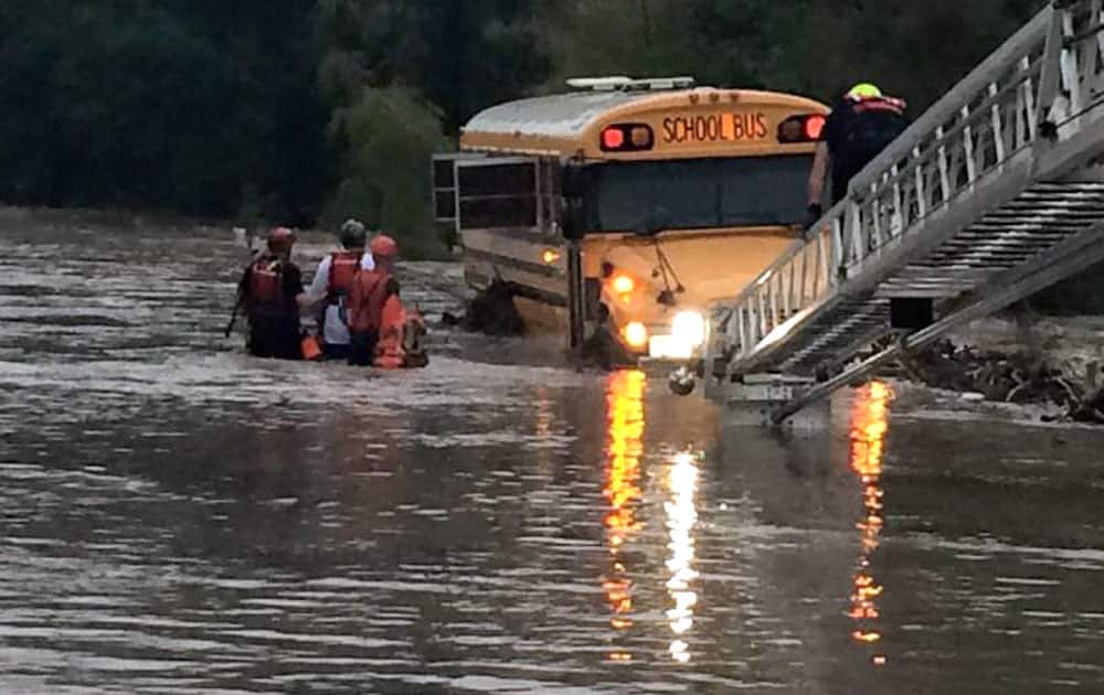 This undated photo provided by the Bexar County Sheriff’s Office, emergency personnel rescue four special needs students and two adults from a school bus caught in floodwater near San Antonio, Texas. The vehicle became trapped as storms swamped parts of Central and South Texas. 
