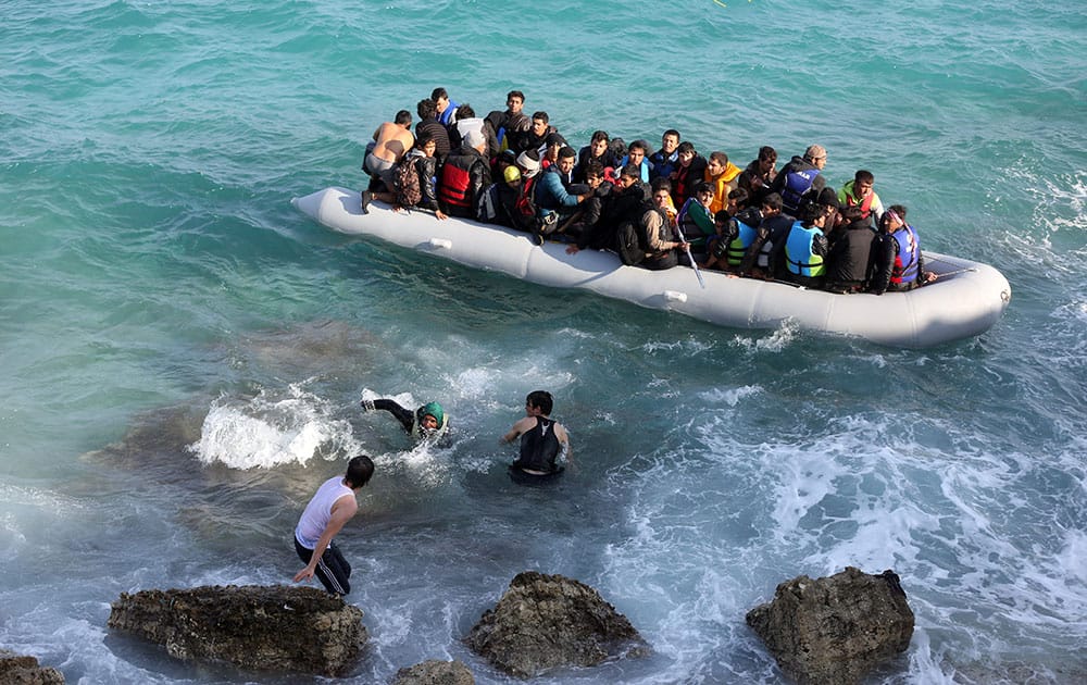 Refugees and migrants board a dingy as they set out, trying to travel from the Turkish coast to the Greek island of Chios, near Cesme, Turkey.