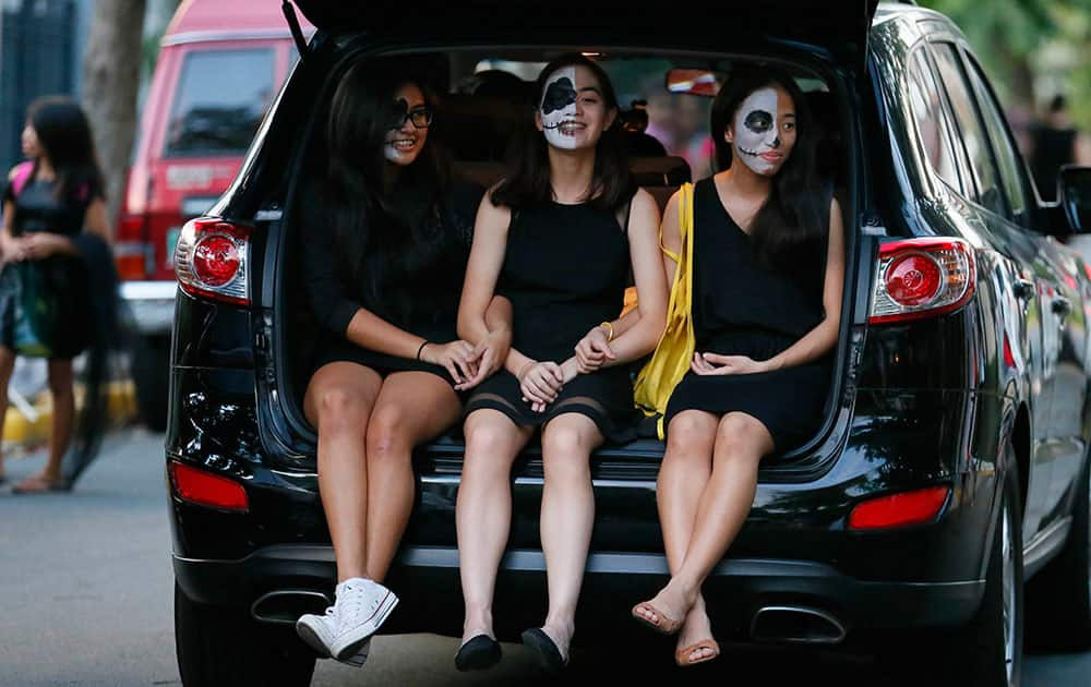 Girls, in their Halloween costumes, ride in the back of an SUV to collect candies and sweets known as 'trick or treat' on Halloween, the eve of the observance of All Saint's Day among Roman Catholics, at suburban Makati city east of Manila, Philippines.