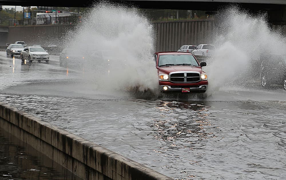 A truck drives through high water on Interstate 45 North near Cottage street as heavy rains fall in the area in Houston. 