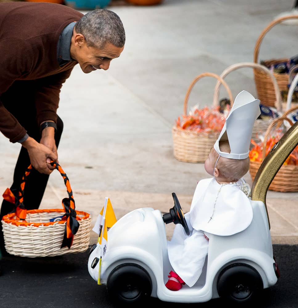 President Barack Obama greets a child dressed as the Pope during Halloween festivities at the South Portico of the White House in Washington.