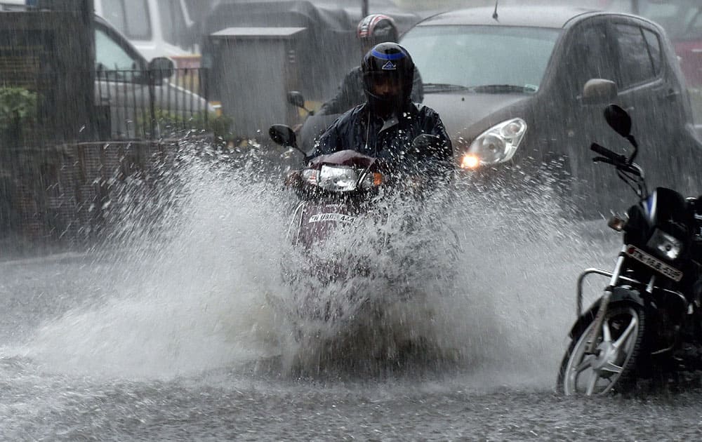 Vehicles move through a waterlogged road after rains in Chennai.