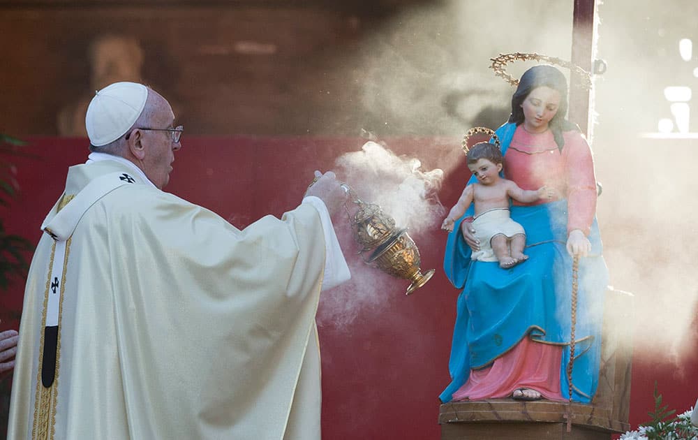 Pope Francis incenses a statue of the Virgin Mary with baby Jesus as he arrives to celebrate mass at Romes Verano cemetery, on the occasion of All Saints Day festivity.