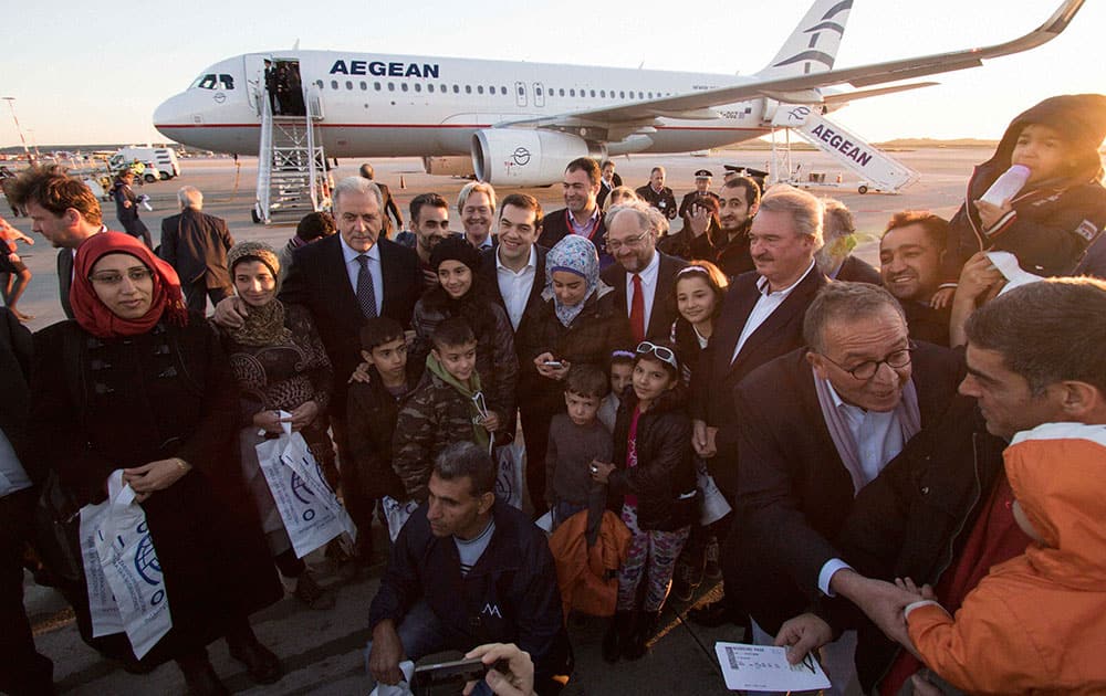 Greeces Prime Minister Alexis Tsipras, center, the President of the European Parliament Martin Schulz, center right, Foreign Minister of Luxembourg Jean Asselborn, 2nd right, and European Commissioner for Migration Home Affairs Dimitris Avramopoulos, centre left, pose with refugees at the Athens International airport.