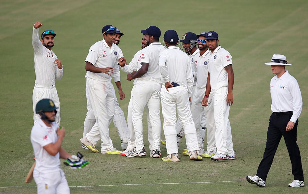 Virat Kohli and his team celebrate the wicket of South Africa's Faf du Plessis who was bowled by Ravindra Jadeja during the first day of their first cricket test match in Mohali.