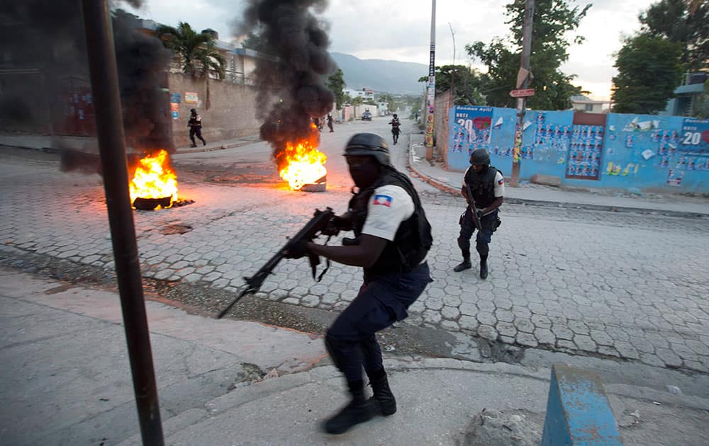 National policemen hold their guns as they secure the area of a protest by supporters of Presidential candidate Moise Jean-Charles against official results just announced by the Electoral Council in the neighborhood of Delmas 33, Port-au-Prince, Haiti.