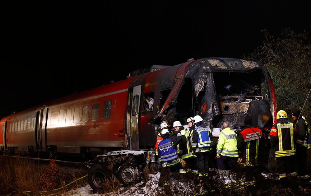 Firefighters stand at the site where a regional train collided with a truck near Freihung, east of Nuremberg, southern Germany.