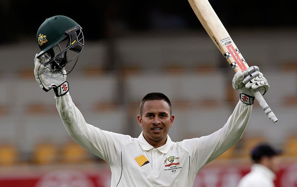 Australia's Usman Khawaja celebrates reaching 100 runs during play on day one of the first cricket test between Australia and New Zealand in Brisbane, Australia.