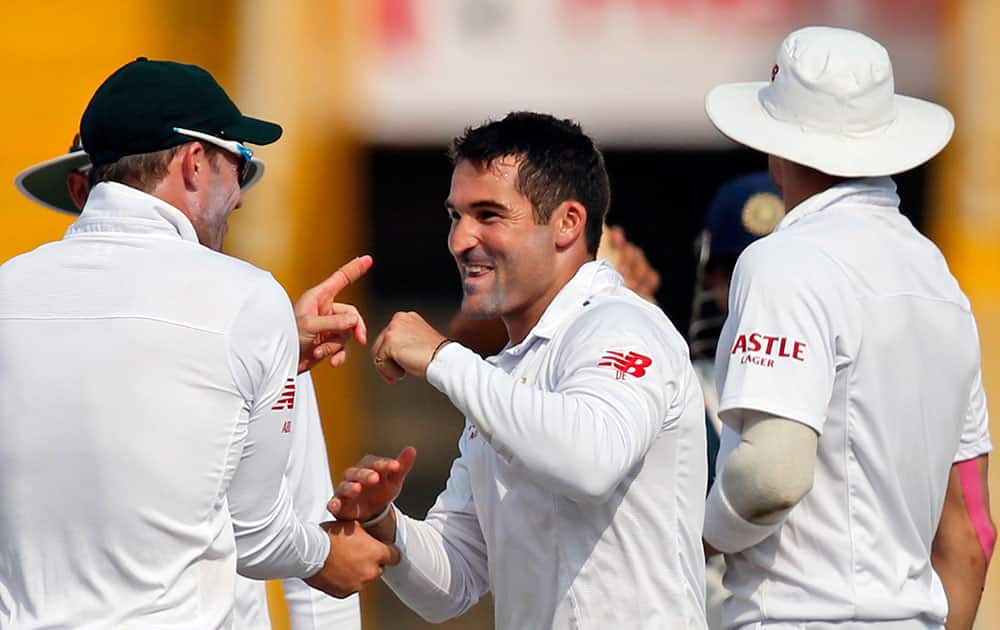 South Africa's Dean Elgar, center, celebrates the dismissal of India's Amit Mishra during the first day of their first cricket test match in Mohali.