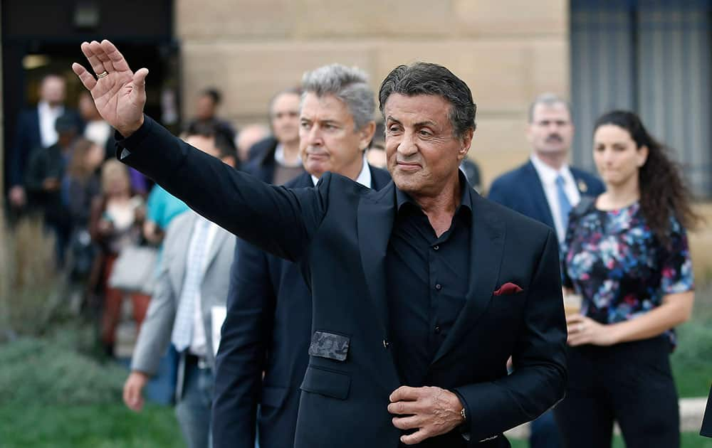 Actor Sylvester Stallone waves to fans as he arrives for a press conference promoting his film 