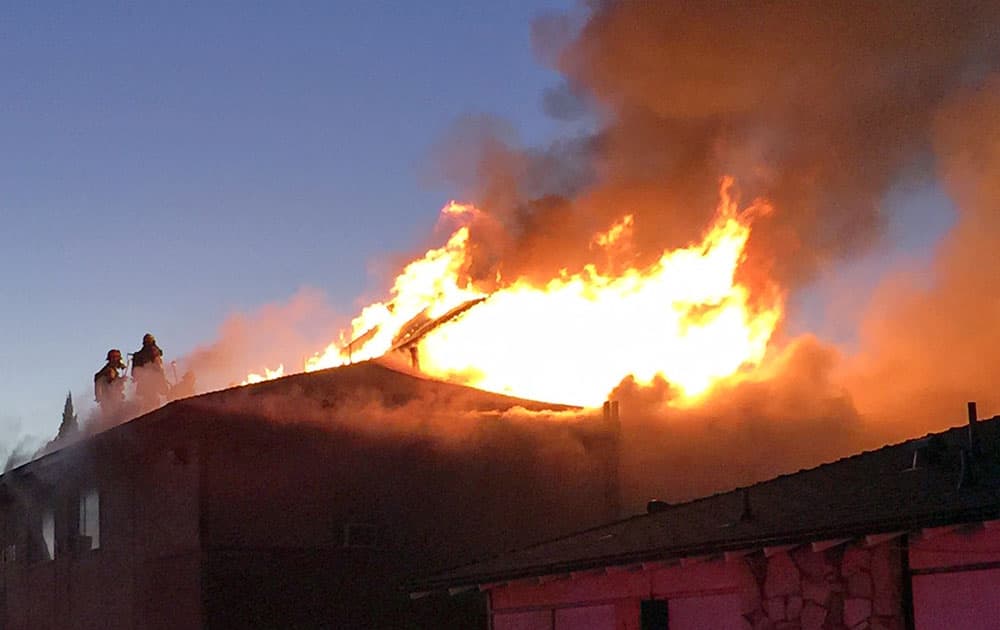 This photo provided by Anaheim Fire & Rescue, firefighters battle a blaze at two apartment complexes, in Anaheim, Calif. 