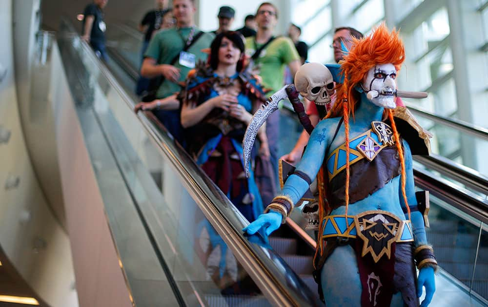 A woman dressed as Voljin from the video game World of Warcraft rides an escalator at the BlizzCon.