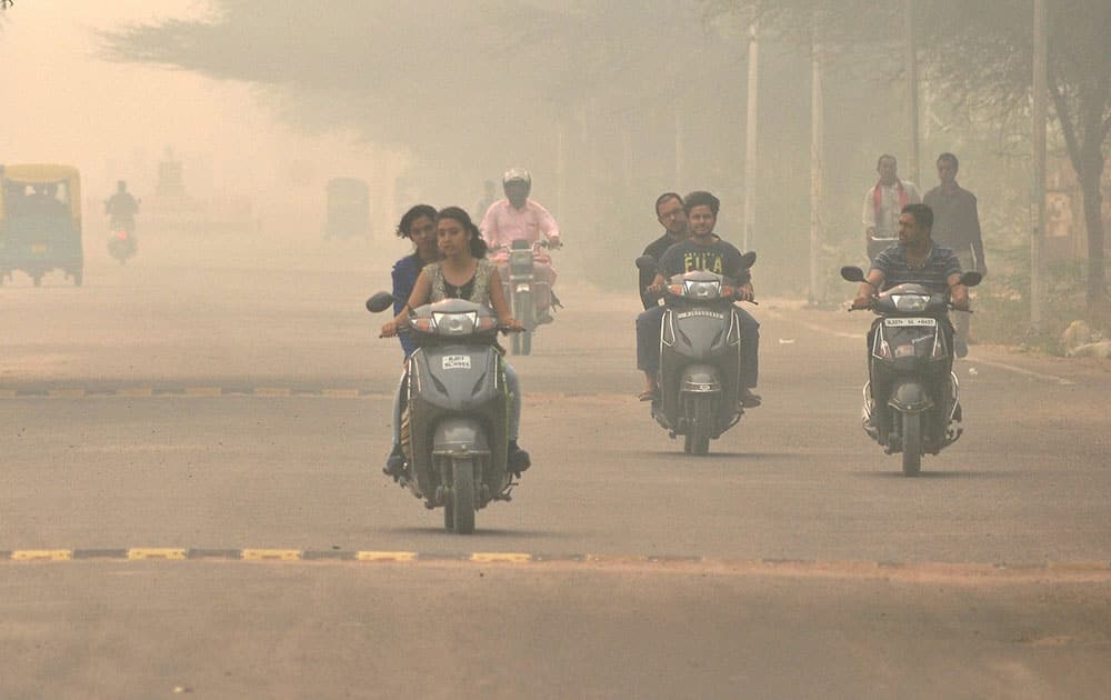 People commute during a foggy morning in Bikaner.