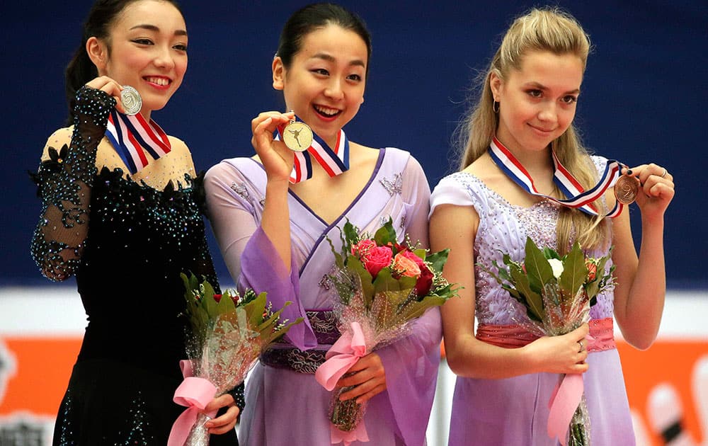 Silver medalist Rika Hongo of Japan, left, gold medalist Mao Asada of Japan, center, and bronze medalist Elena Radionova of Russia.