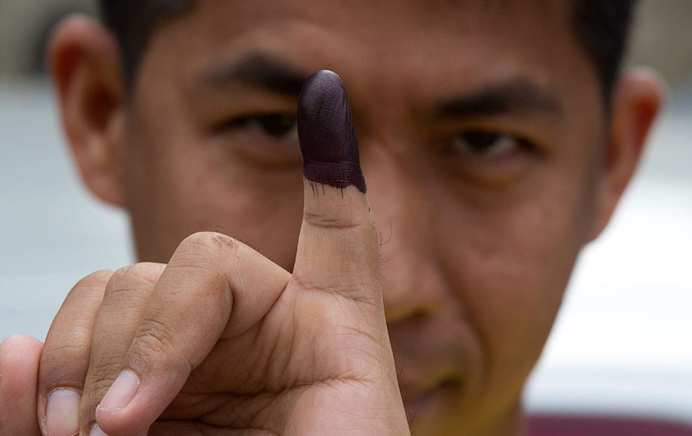 A man shows his finger marked with ink indicating he had voted in Yangon, Myanmar.