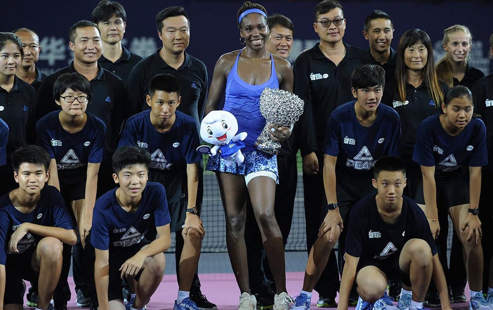 Winners Venus Williams of the United States poses with ball boys and girls after the award ceremony for the 2015 WTA Elite Trophy tennis tournament in Zhuhai in southern Chinas Guangdong province.