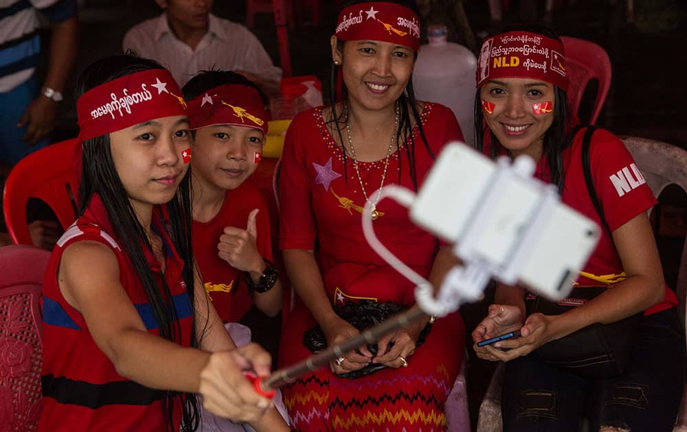 A group of opposition supporters take a selfie as hundreds of people gather outside the opposition party headquarters despite rain in Yangon, Myanmar.