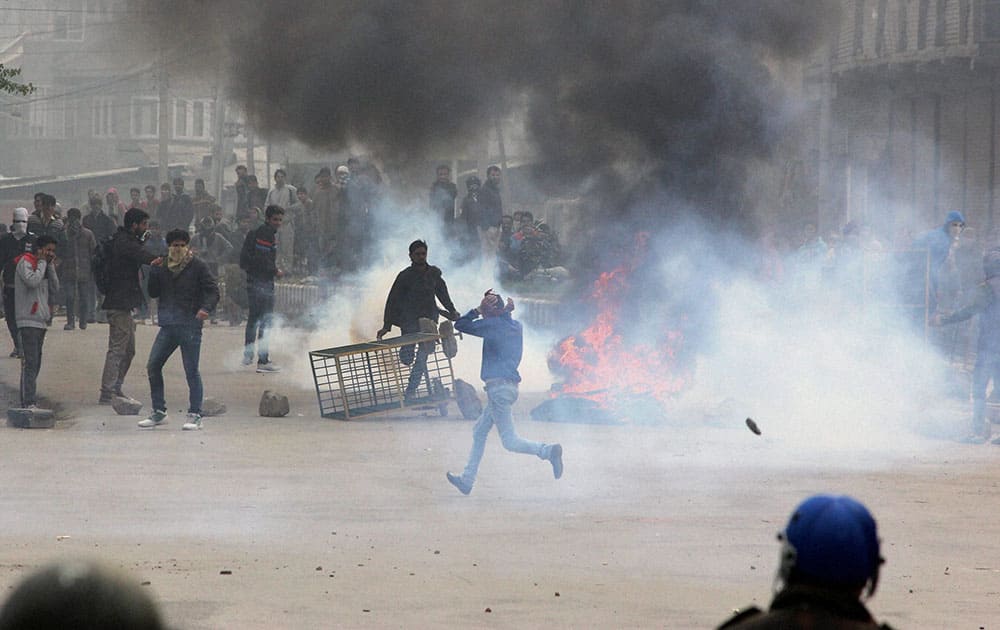 Protesters amid tear smoke throwing stones at the police during a clash over the killing of a 21-year-old youth at Gojwara in Srinagar.