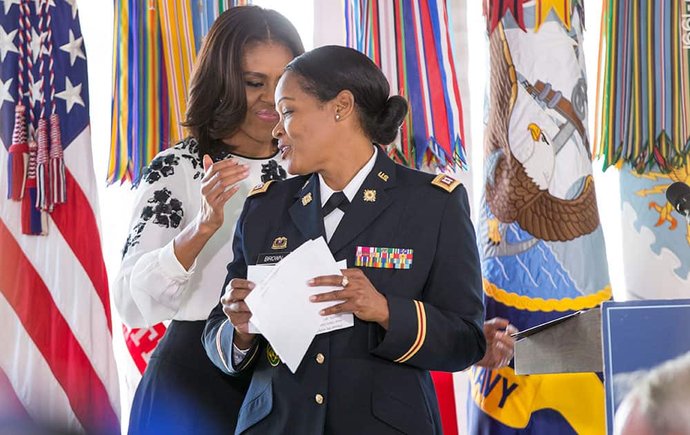 First lady Michelle Obama applauds Capt. Capt. Rolana Brown of High Point, N.C., during a luncheon for military women, active-duty service members and veterans, spouses and caregivers, at the Vice President's official residence at the Naval Observatory in Washington.
