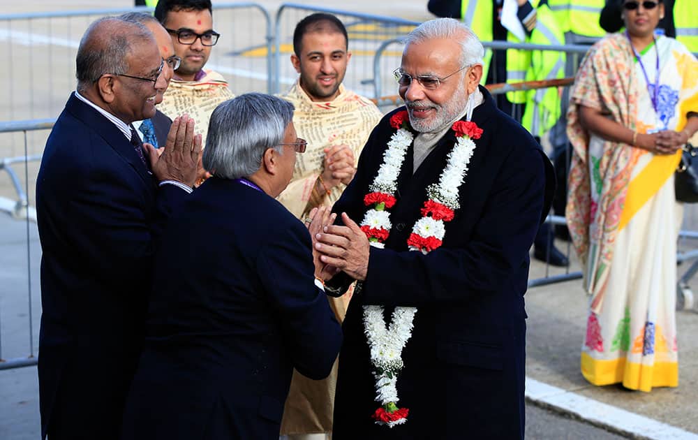Indian Prime Minister Narendra Modi is presented with a garland of blossoms in celebration of Hindu new year as he arrives at Heathrow Airport, London, for an official three day visit.
