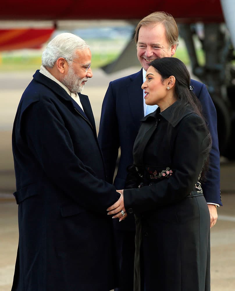 Indian Prime Minister Narendra Modi, left, is greeted by Minister of State for the Foreign and Commonwealth Office, Hugo Swire and MP Priti Patel as he arrives at Heathrow Airport, London, for an official three day visit.