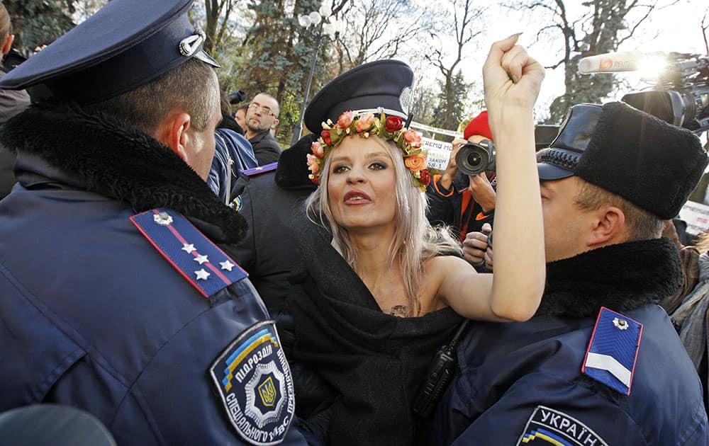 Policemen detain a Femen womens movement activist in front of the parliament building in Kiev, Ukraine.