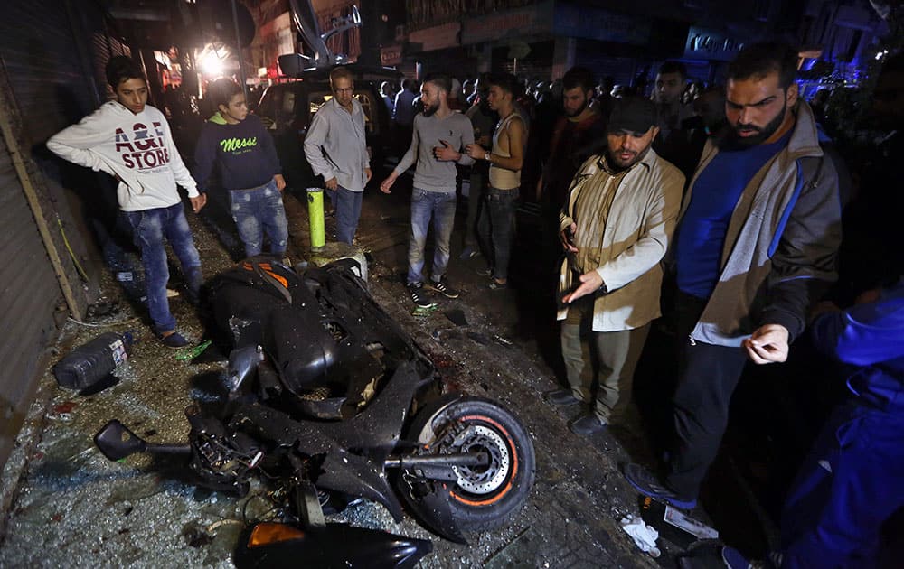 People gather near the site of a twin suicide attack in Burj al-Barajneh, southern Beirut, Lebanon.
