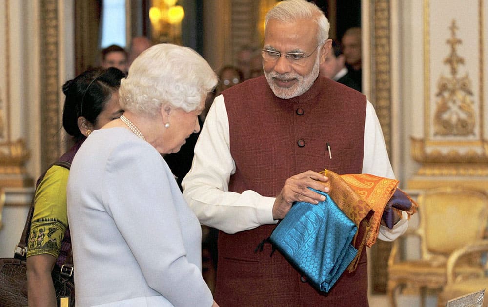 Prime Minister Narendra Modi present gifts to Queen Elizabeth II at Backingham Palace in London.