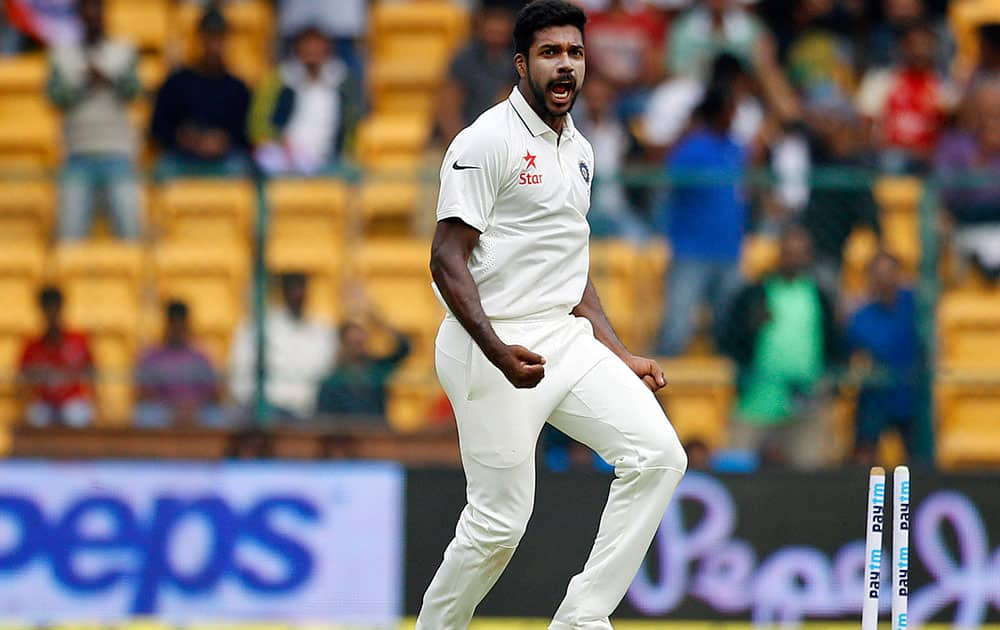 Varun Aaron celebrates the dismissal of South Africa's captain Hashim Amla during the first day of their second cricket test match in Bangalore.