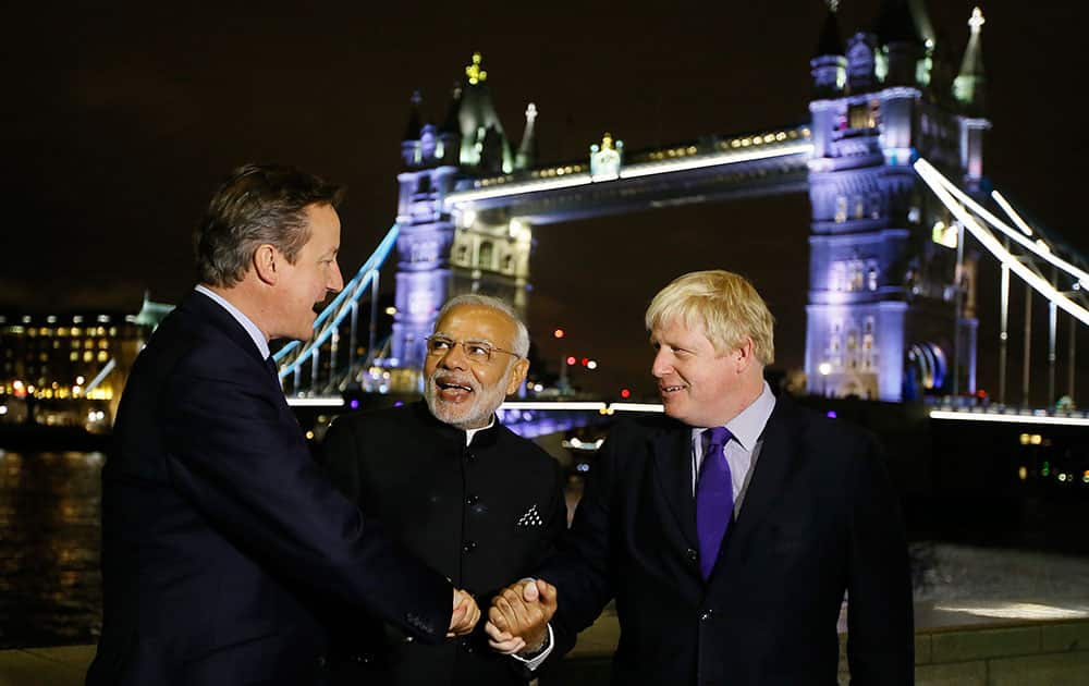 Britain's Prime Minister David Cameron with India's Prime Minister Narendra Modi and the Mayor of London Boris Johnson hold hands in front of Tower Bridge in London.