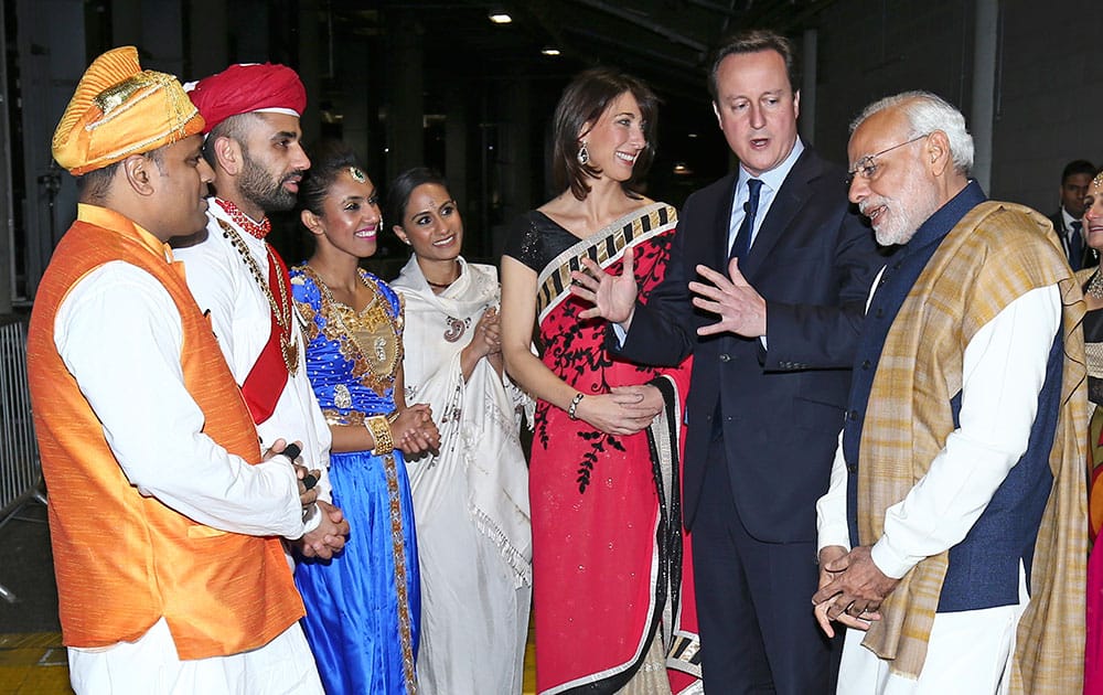 India's Prime Minister Narendra Modi with British Prime Minister David Cameron and his wife Samantha, meet artists and performers in a backstage area at Wembley Stadium in London.