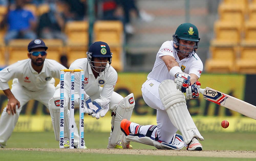 Ajinkya Rahane and Wriddhiman Saha watch South Africa's Dean Elgar play a shot during the first day of their second cricket test match in Bangalore.