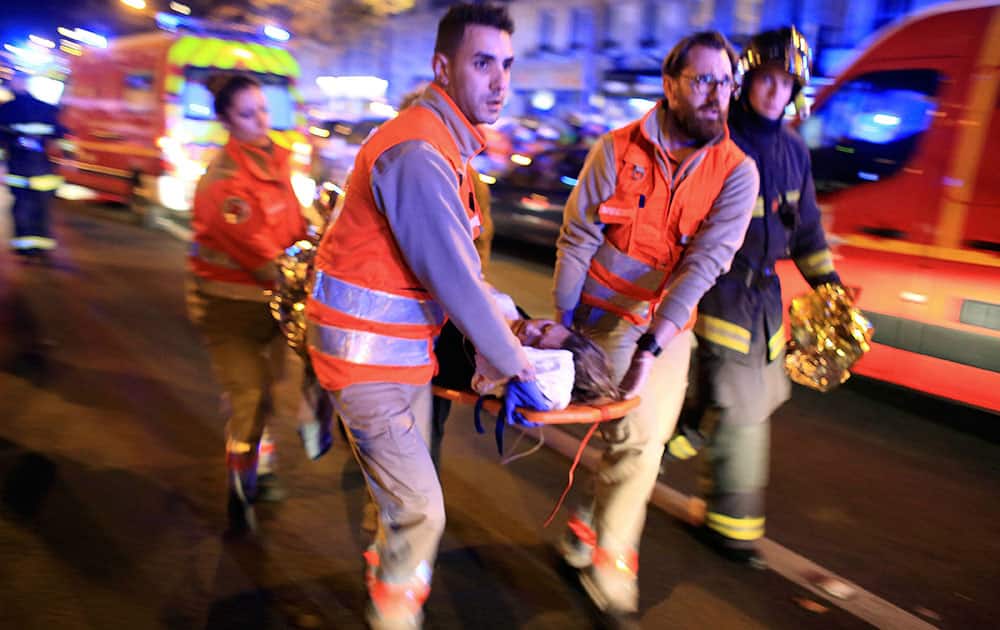 A woman is being evacuated from the Bataclan theater after a shooting in Paris.