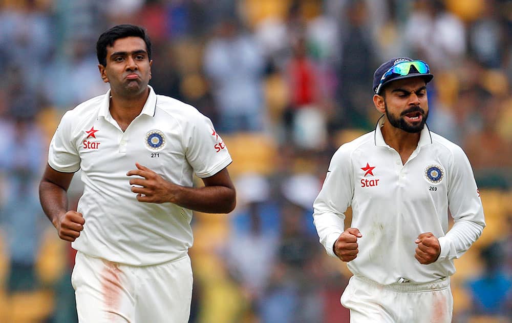 Ravichandran Ashwin and captain Virat Kohli celebrate the dismissal of South Africa's Morne Morkel during the first day of their second cricket test match in Bangalore.