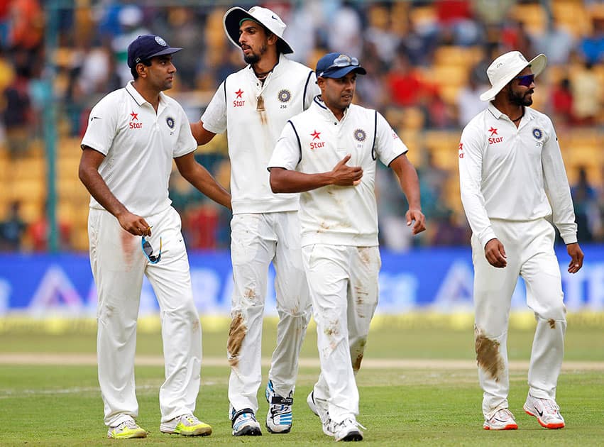 Indian players from left, Ravichandran Ashwin, Ishant Sharma, Stuart Binny and Ravindra Jadeja leave the ground at the end of South Africa's innings during the first day of their second cricket test match in Bangalore.