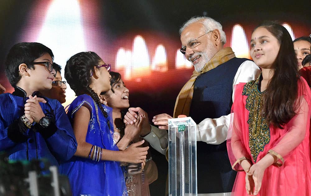 Prime Minister Narendra Modi interacts with children after addressing the Indian community at Wembley stadium in London.